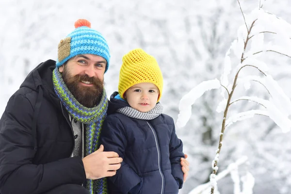 Πατέρας και γιος, πρόκειται για μια βόλτα στη χειμωνιάτικη ημέρα. Ευτυχισμένη οικογένεια. Θετικά ανθρώπινα συναισθήματα, συναισθήματα, χαρά. Ο πατέρας αγκαλιάζει ένα γιο στο χιονισμένο δάσος. Χειμερινή ώρα. Μικρά και μεγάλα φίλος, ευτυχισμένη παιδική ηλικία — Φωτογραφία Αρχείου
