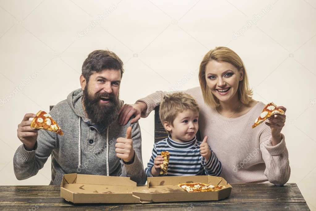 Emotional family. Cute boy shows finger up thumbs up for delicious pizza for lunch. Happy family sharing pizza together at home. Cute little kid eating pizza. Hungry child and smiling family parents