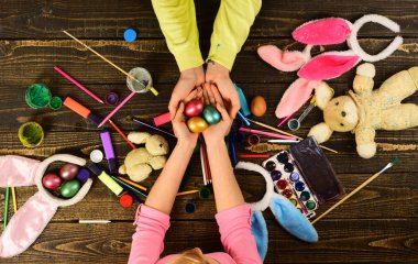 Mutlu Paskalya kavramı. Paskalya yumurtaları ile aile el, tebrik kartı, tavşan ve el için renkli yumurta dekorasyon yapılan