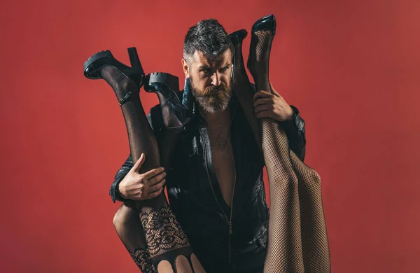 Womanizer. Homme brutal barbu avec des jambes féminines en collants sexy. Une relation sensuelle séduisante. Passion et polygamie. Mode et beauté. Proxénète et agent modèle. Homme et deux femmes, jambes séduisantes — Photo