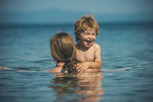 海のママ, 家族休暇, 休日で海に幸せな子です。夏の最後の分のツアー。夏休み水、幸せな家族、赤ちゃんの男の子の子供を持つ母です。親が泳ぐ面白い子供を教えています。 — ストック写真