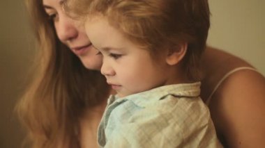 Bebek ve anne portre Portreler. Mutlu aile, genç sarışın anne ve oğlu komik saç modeli ile. Tatlı çocuk annesi kollarında. Annelik ve çocukluk, sevgi, bakım ve anlayış. Sabah veya akşam pijama