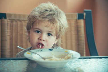 Komik spagetti. Çocuk spagetti yiyor. Çocuklar için İtalyan yemeği. Yemekte tatlı çocuk..