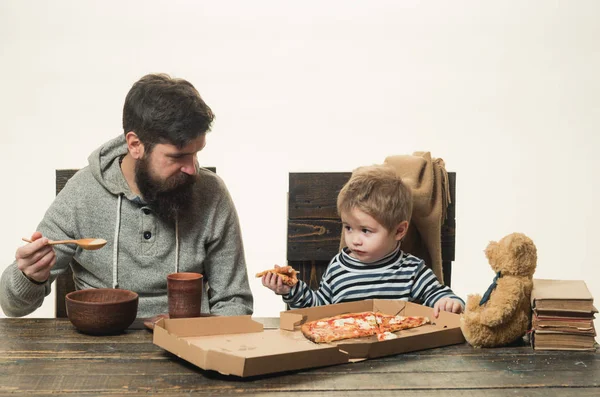 食欲が悪い。子供はピザを食べたくない。父は子供を養おうとしている. — ストック写真