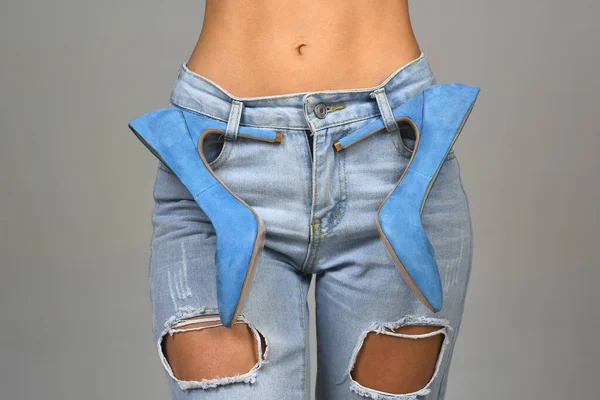 Kotlu ve yüksek topuklu mavi ayakkabılı çıplak midesi olan seksi bir kız. Şık kıyafetler ve ayakkabılar. Tarz ve moda. Denim geçmişi. Modern kadın, stil ikonu. Mavi konsept. Kıyafet tasarımcısı.. — Stok fotoğraf