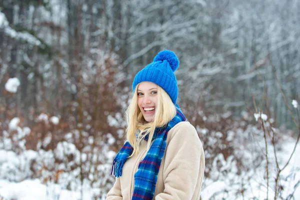 Belle blonde au chapeau bleu chaud. Style d'hiver pour les jeunes femmes. Belle jolie sourire féminin. Forêt d'hiver et bonne humeur dans le temps glacial . — Photo