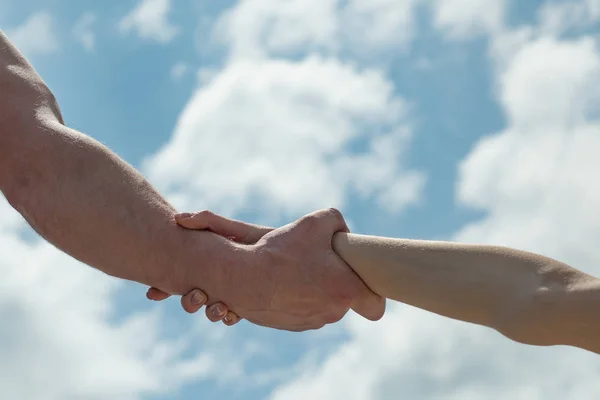 Helping hand. Mutual support and revenue. Friends. Two hands together against the sky. Marriage. Wife and husband.