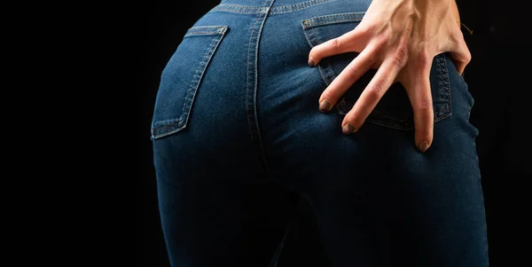 Vaqueros. La joven sostiene una mano en las nalgas. Manicura de lujo y ropa de moda . —  Fotos de Stock