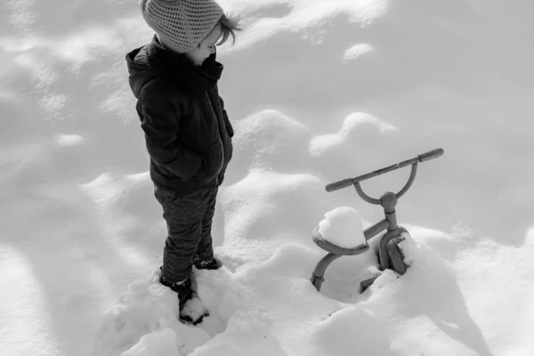 Ποδήλατο κάτω από χιόνι. Μεγάλος παγετός για το νέο έτος. Το αγόρι κοιτάζει τη μεταφορά του κάτω από το χιόνι. Κατάρρευση μεταφορών το χειμώνα. — Φωτογραφία Αρχείου