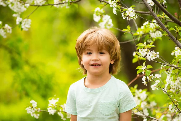Feliz niña. El chico sonriente. Lindo niño en un fondo de bosque de primavera . —  Fotos de Stock