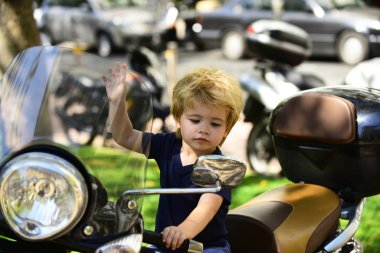 Uzak görüşün aynası. Motosikletli yakışıklı çocuk aynaya bakıyor, trafik kuralları, ehliyetli sürücü, yolculuktaki küçük sürücü, yol ve maceralar..