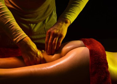 Özel masaj. Kadın kalçaları ve erkek elleri..