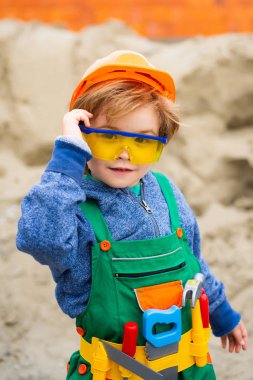 İnşaatçı çocuk. İnşaat alanında gözlüklü bir çocuk. Müteahhit için uygun..