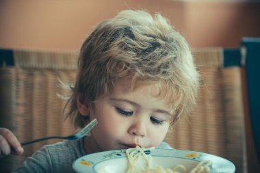 Cute child with spaghetti. Lunch for children. Child with pasta fork