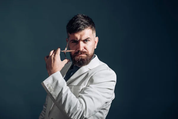 Un homme avec des ciseaux. Concept de salon de coiffure. Coiffeur pour hommes. Élégant gars . — Photo