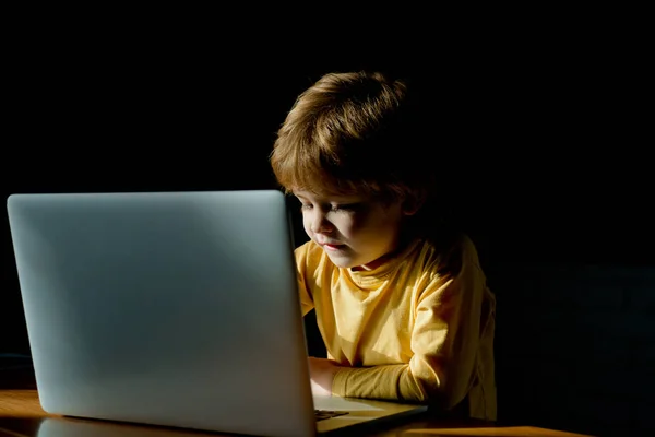 Egy fiatal üzletember laptopot használ. Vicces gyerek. Divatportré egy jóképű fiúról az irodában. Az iskolás gyerek laptopot használ. Tanulmányozás és oktatás. — Stock Fotó