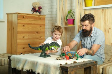 Aile oyunu. Çocuk, baba ve dinozor. Çocuk hobileri. Oğlan ve baba.