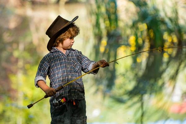 Coge la pesca. El chico atrapa un pez grande con una caña de pescar. Fin de semana en la naturaleza salvaje . — Foto de Stock