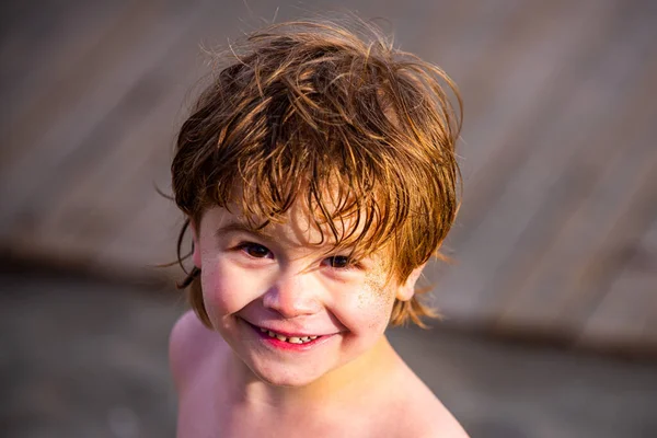 С летним детским портретом. Улыбающийся мальчик с мокрыми волосами после воды. Купание в море. Красивое детское лицо. Прекрасный очаровательный мальчик. . — стоковое фото