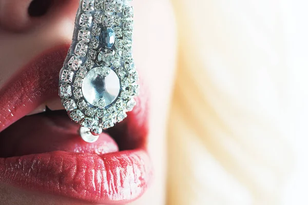 Luxury lips and jewelry. Luxury lifestyle. Macro and close up creative theme, beautiful female lips with pink lipstick, white diamonds and teeth. Seductive tongue. — Stock Photo, Image