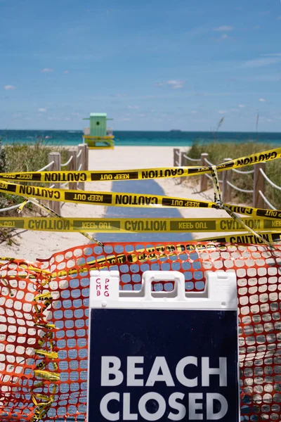 Пляж закрыт Ковид 19, социальная изоляция в США, Америке. Социальное дистанцирование, будьте осторожны, чтобы победить коронные вирусы. Символ риска для здоровья. Майами Бич закрыт. Знак предосторожности. Карантин возле океана . — стоковое фото