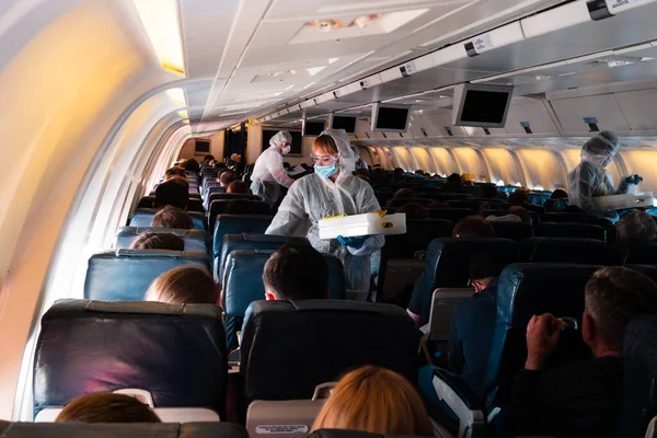 Covid 19 coronaviruse ταξιδιωτική προστασία. Πλήρωμα αεροσκαφών με προστατευτικές στολές και μάσκες κατά τη διάρκεια ενός πανδημικού ιού του στέμματος. Επιβάτες πετούν στην Αμερική, επαναπατρισμός Αμερικανών πολιτών στις ΗΠΑ με αεροπλάνο. — Φωτογραφία Αρχείου
