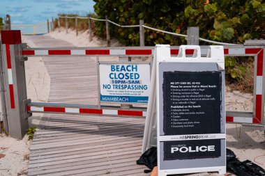 Miami plajı kapalı tabelası. Florida 'da polis kısıtlamaları. Covid 19, Amerika 'da sosyal tecrit. Sosyal mesafeler güvenli kalmalı. Sağlık riski. Miami plajı uyarı tabelası. Okyanus kıyısındaki karantina.