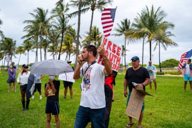 Miami Beach, Florida, ABD - 10 Mayıs 2020 Coronavirus protestosu. Protestocular Güney Sahili İşletmelerinin yeniden açılmasını ve Yüz Maskelerinin isteğe bağlı hale getirilmesini istiyor. Miami Lummus Parkı 'ndaki protestocular.