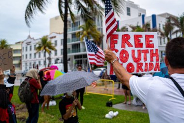 Miami Beach, Florida, ABD - 10 Mayıs 2020: Free South Florida tabelası ve ABD bayrağı. Miami Plajı 'ndaki Lummus Park' taki protestocular Coronavirus salgınının ortasında belediyeye plajların ve ekonominin yeniden açılmasını talep ediyorlar..