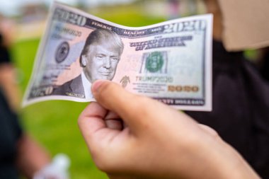 Miami Beach, Florida, ABD - 10 Mayıs 2020 Trump 'ın portresi olan sahte dolar. Para 2020. Miami protestosundan bir banknot. Coronavirus gösterisi. Elinde sahte para var. Trump Seçmenleri. Nakit.