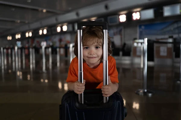 Reistassen. Kind in een leeg vliegveld. Een jongen met een koffer reist de wereld rond. Coronavirusproblemen. Einde quarantaine en reis. — Stockfoto