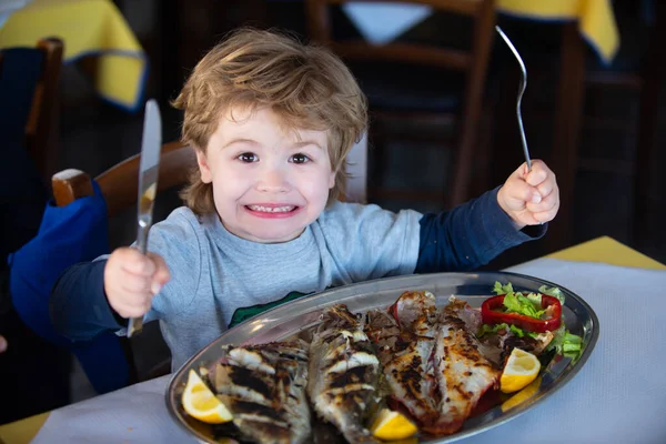 海での休暇。海のランチだ。クルーズで昼食。子供は夕食に海魚を食べる。子供の健康食品. — ストック写真