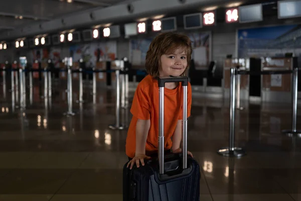 Gelukkige jongen met een koffer op het vliegveld. Reizen. — Stockfoto