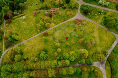 Yeşil bir parkta yollar kesişiyor.