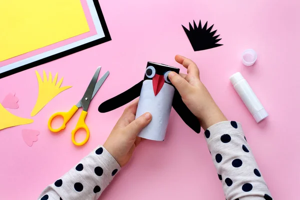 Making a penguin from colored paper and a roll of toilet paper. Children\'s art project. Step by step photo instruction. Step 6. Glue the penguin\'s eyes.