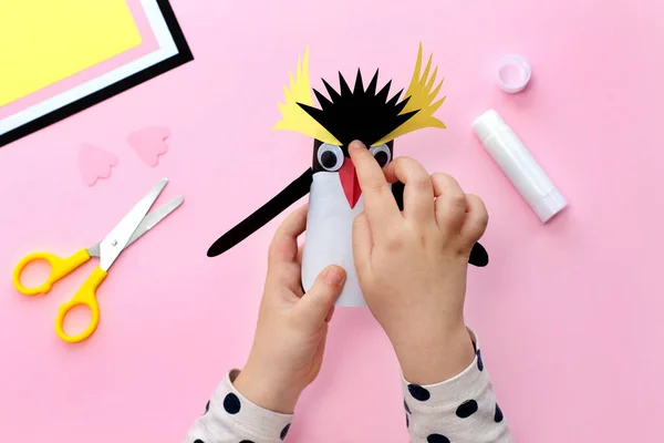 Making a penguin from colored paper and a roll of toilet paper. Children's art project. Step by step photo instruction. Step 8. Glue black crest.