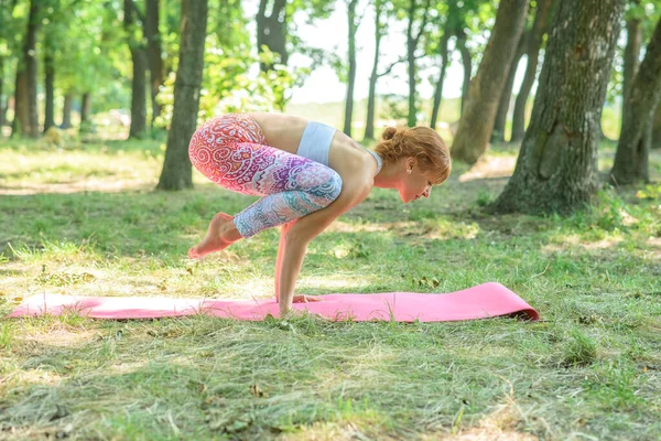 Young girl doing yoga in the forest on a sunny day