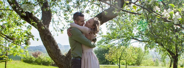 Familj i blommande trädgård, unga familj på en promenad, maj — Stockfoto