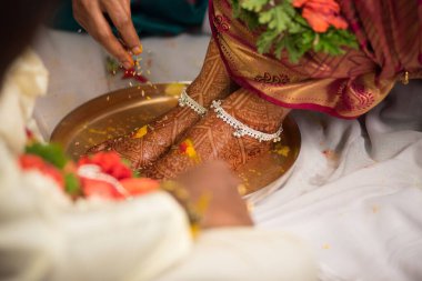 Düğün sırasında geleneksel bir ayin yapılırken, Hintli bir gelinin süslü ayaklarının yakın çekimi.