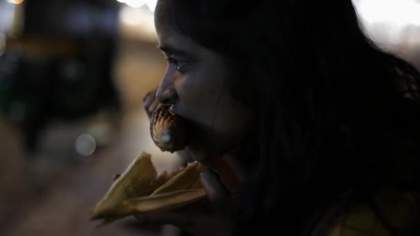 一名亚洲南印度妇女在晚上吃玉米芯的近照 背景是交通拥挤 — 图库视频影像