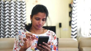 Cep telefonu kullanan genç bir Hintli kadın. 