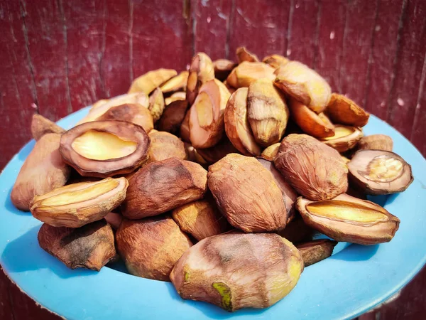 Bir tabak kuru mango dilimi, olgunlaşmamış mango, tohum, dilimleri ve parçaları güneş ışığında kurutmak için tabağa dizilmiştir. Yakın görüş, seçici odaklanma..