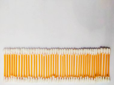 Hafif arka planda kulak çubukları ya da pamuklu kulak çubukları var. Hijyen için kulak bakım konsepti.