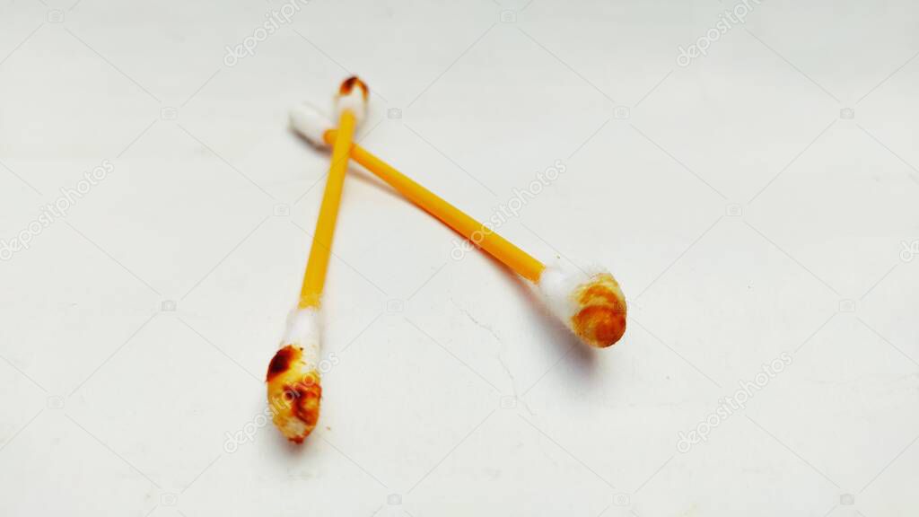 A pair of used ear swabs or cotton ear sticks on the light background. Ear care concept for Contain Earwax.