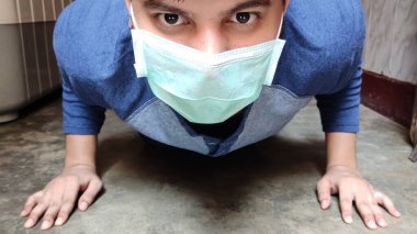 Evde maske takan adam egzersizi, şınav, kalas ve yoga, CORONA, COVID 19 Salgın, Seçici Odaklanma.