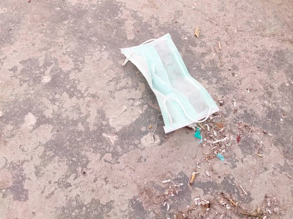 Dirty Face mask  ground in dustbin  ,after use mask thrown.