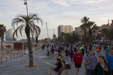 Barselona, İspanya, 02 Mayıs 2020. Covid-19 krizi yüzünden İspanya 'daki tecridin ilk günü. Yetişkin insanlar Barceloneta 'da yürüyor ve hükümetin önerdiği program dahilinde spor yapıyorlar.
