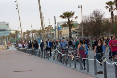 Barselona, İspanya, 02 Mayıs 2020. Covid-19 krizi yüzünden İspanya 'daki tecridin ilk günü. Yetişkin insanlar Barceloneta 'da yürüyor ve hükümetin önerdiği program dahilinde spor yapıyorlar.