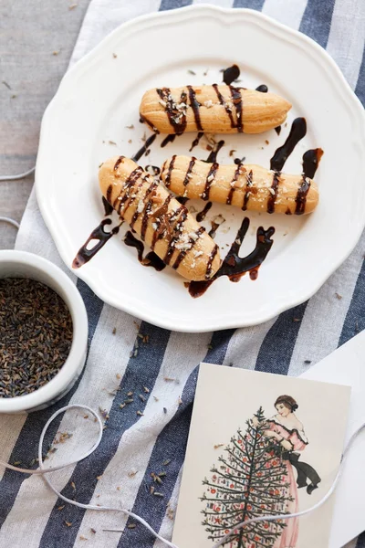 Franse eclairs op wit bord met chocolade — Stockfoto