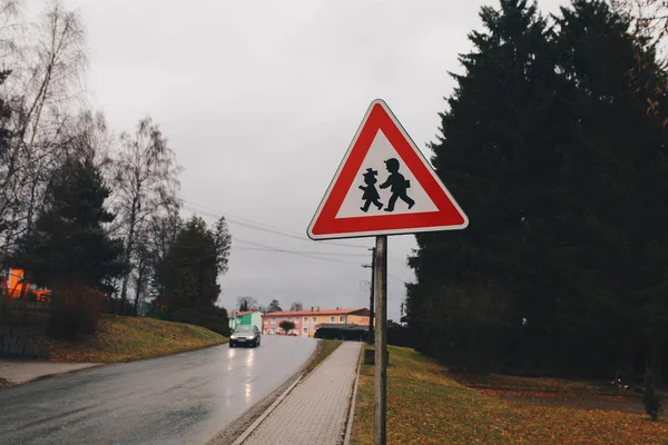 Driehoek straatnaambord met kinderen kleine Europese stad — Stockfoto